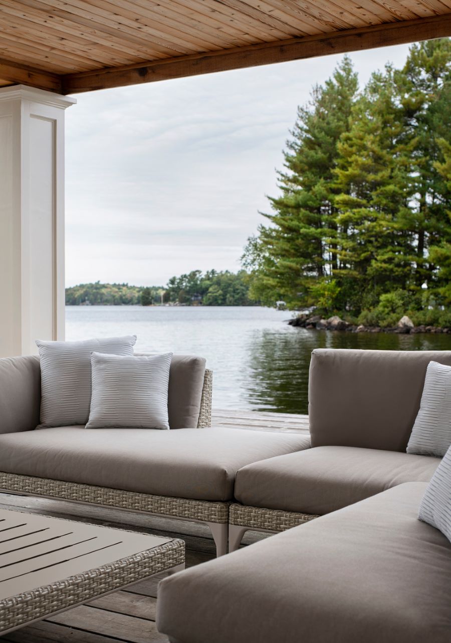 Sivá sedačka na terase s výhľadom na jazero.