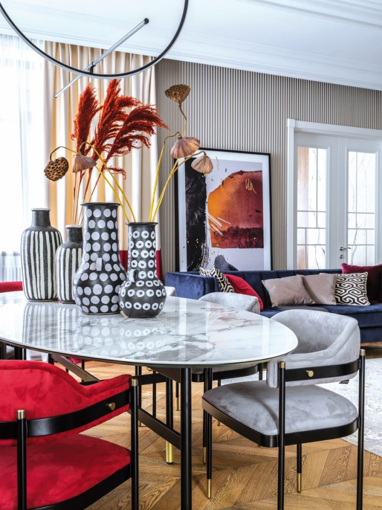 Obývačka s jedálňou so sýtočervenými doplnkami.