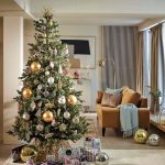 Vianočný stromček s nadrozmernými zlatými vianočnými guľami v interiéri.