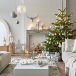 Vianočný stromček s bielymi dekoráciami v bielom interiéri