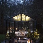 Presklený záhradný domček na dvore s vianočným dekorom.