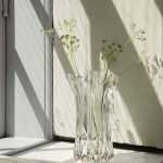 Masívna sklenená váza Holo s rastlinami pri okne.