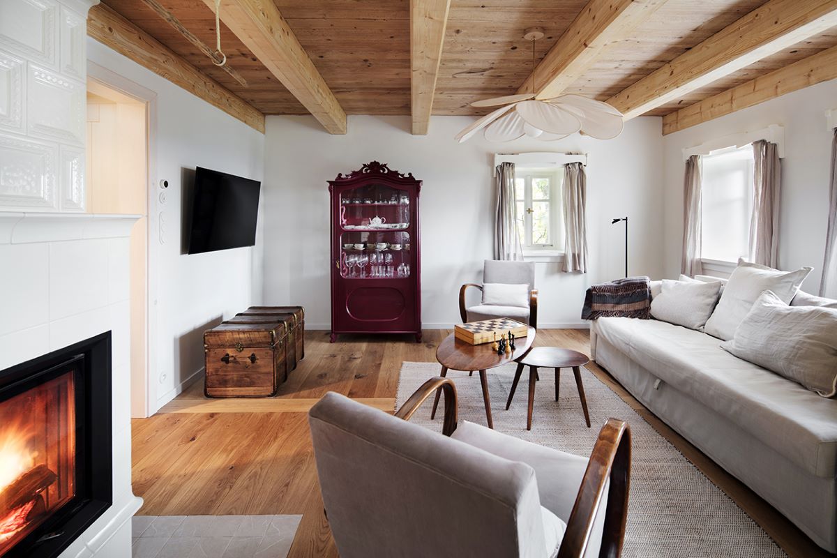 Obývačková časť v chalupe v škandinávskom štýle s kachľovou pecou.