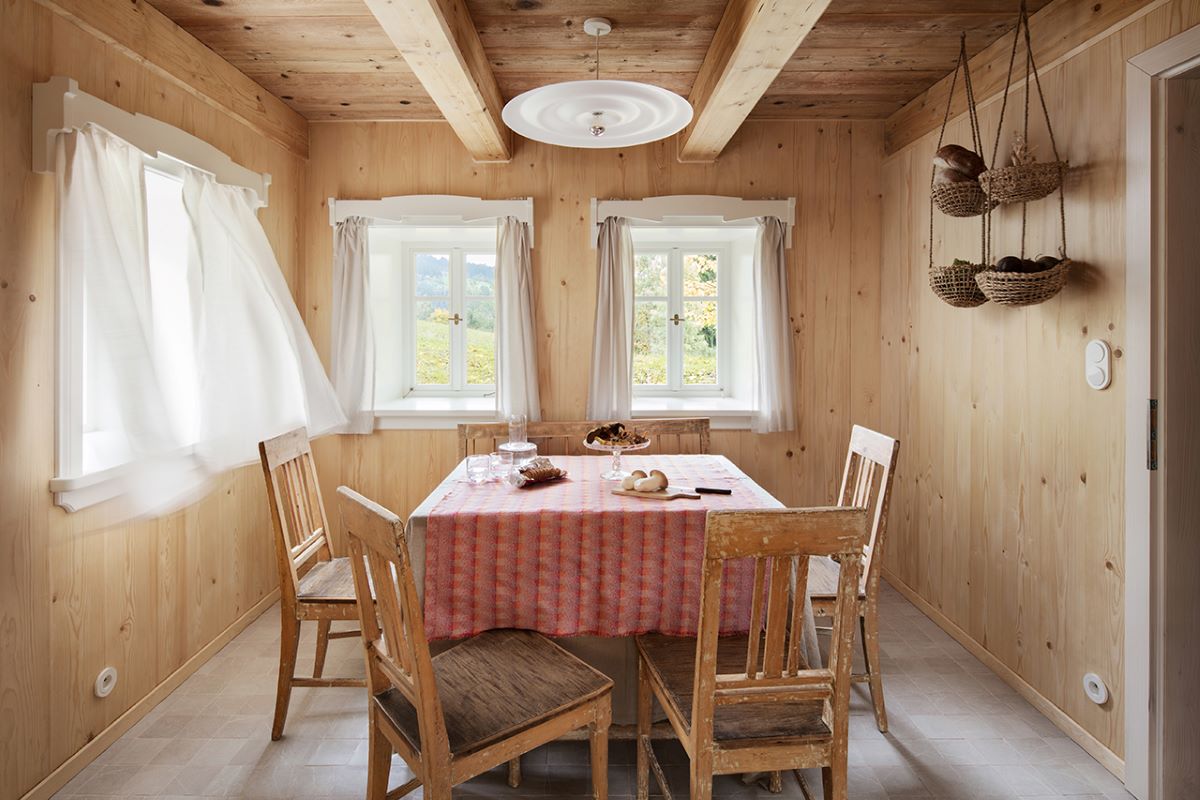 Jedálenská časť druhej kuchyne so stolom a stoličkami v rustikálnom štýle.