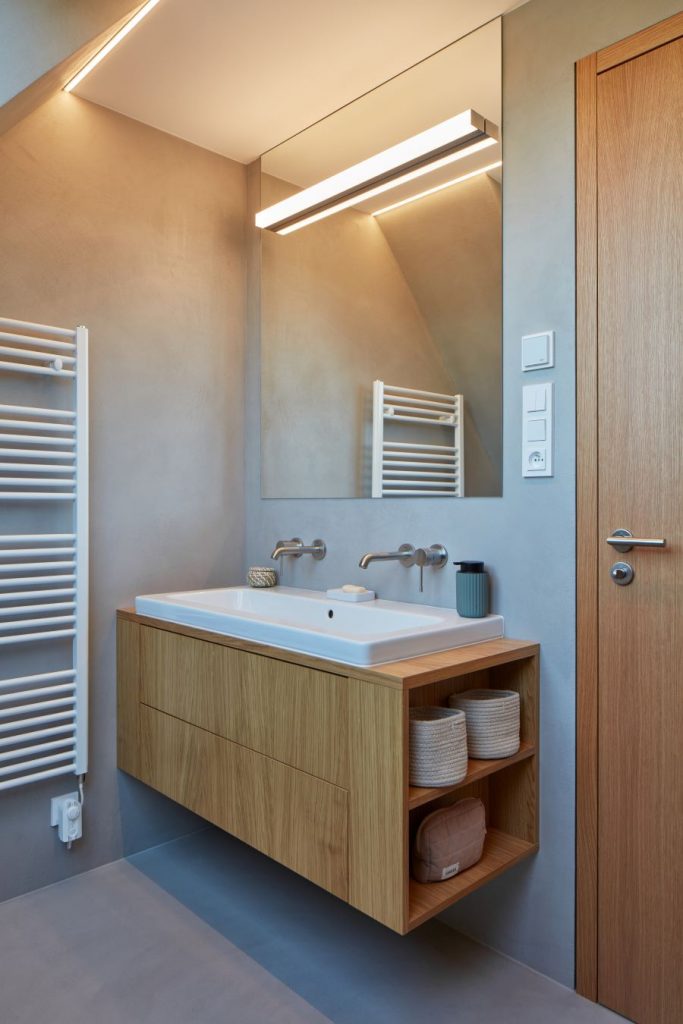 Časť kúpeľne s drevenou skrinkou s dvojumývadlom.