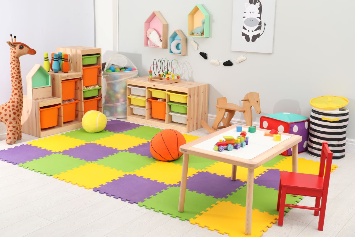 Časť detskej izby s úložnými systémami, hračkami a stolíkom.