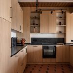 Záber na kuchyňu s drevenu kuchynskou linkou a terakotovými dlaždicami.