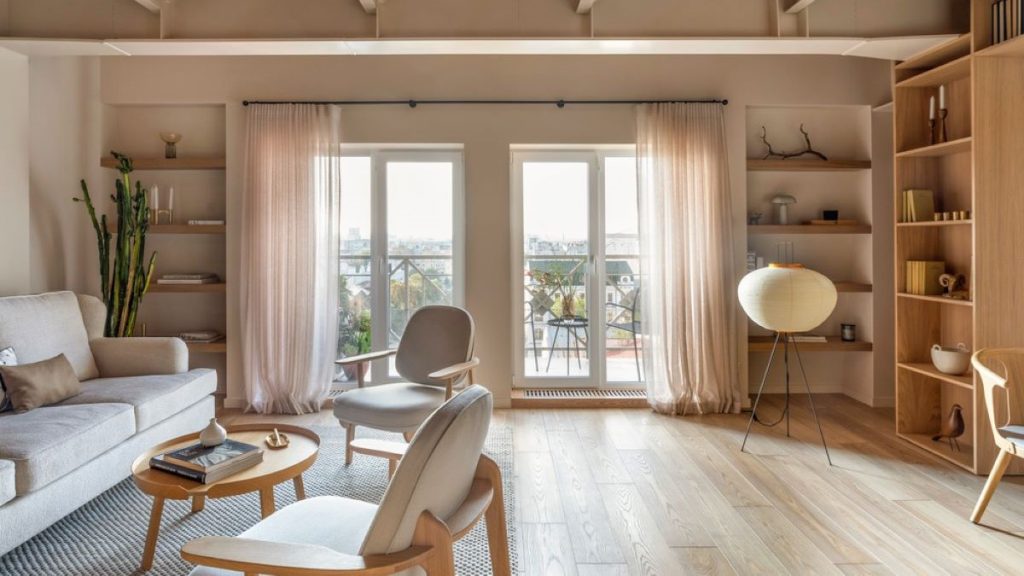 Pohľad na časť obývačky so sedačkou, drevenými policami a vstupom na balkón.