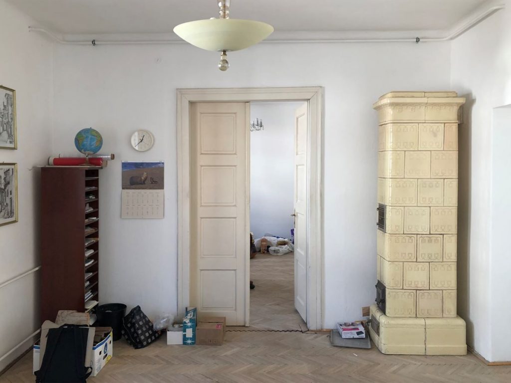 Pohľad na staré dvere a kachľovú pec v neprerobenom byte z 30. rokov.
