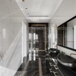 Pohľad do čierno-bielo-zlatej luxusnej kúpeľne s ornamentom.