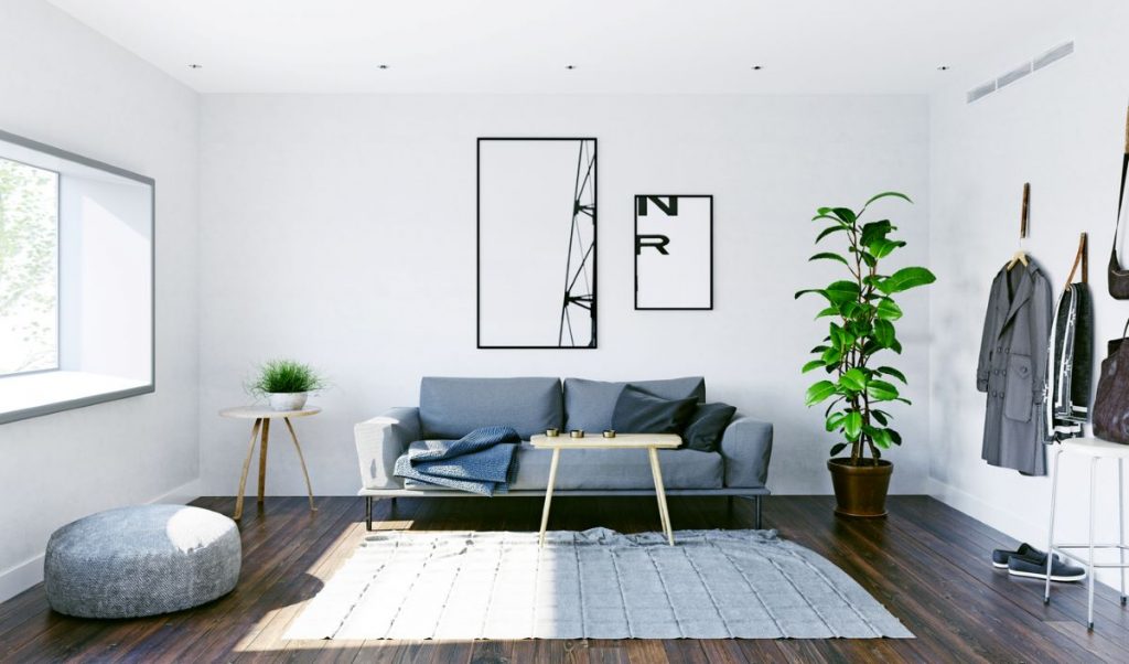 Časť malej obývačky v minimalistickom štýle so sedačkou, taburetkou, stolíkom a vešiakovou stenou.