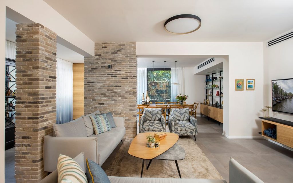 Pohľad do modernej obývačky v neutrálnych tónoch s priechodom do jedálne.