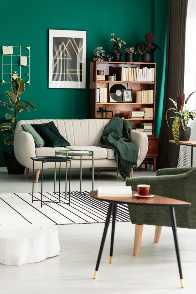 Obývačka so svetlou sedačkou a stenou v odtieni borovicovej zelenej.