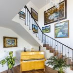 Záber na priestor pod schodami so žltým klavírom.