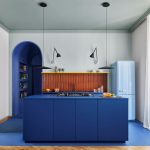 Pohľad na kuchyňu s modrou kuchynskou linkou v byte v Miláne.