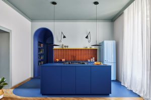 Pohľad na kuchyňu s modrou kuchynskou linkou v byte v Miláne.
