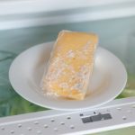 Detail na splesnetý syr na tanieri v chladničke.