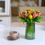 Váza s tulipánmi na stole v interiéri.