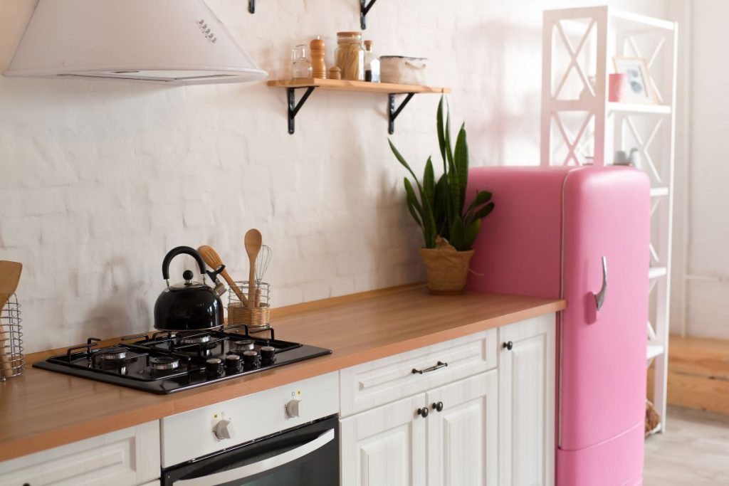 Časť kuchyne s ružovou retro chladničkou.