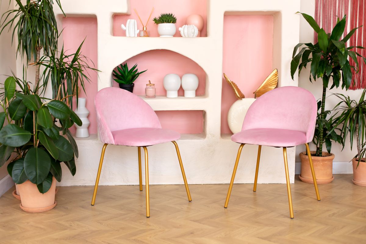 Dve ružové stoličky so zlatými nôžkami.