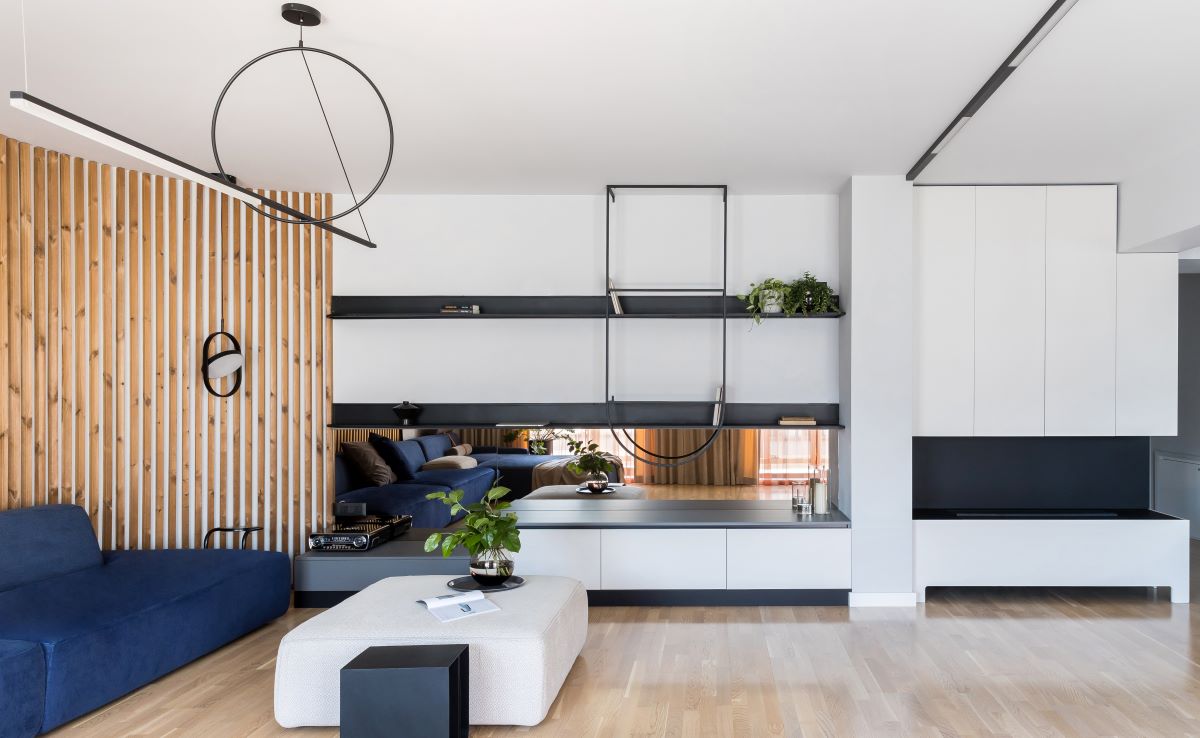 Pohľad na obývačku s čierno-bielym úložným priestorom, lamelami a sedačkou.