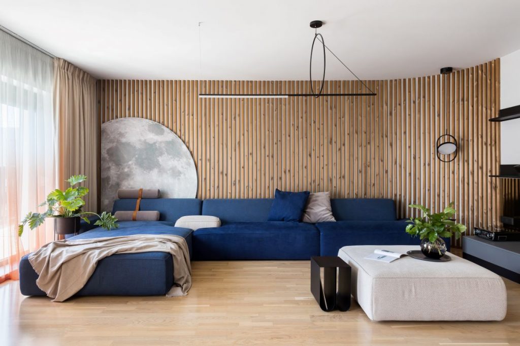 Obývačka so sedačkou a lamelami na stene.