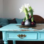 Zavoskované hyacinty na podnose na modrom vintage stole.