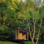 Pohľad na saunu ako oddelenú súčasť chaty Hytta medzi stromami.