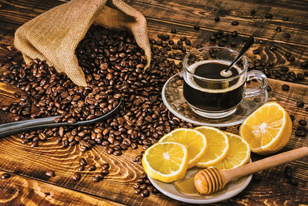 Šálka kávy, plátky citróna a kávové zrnká.