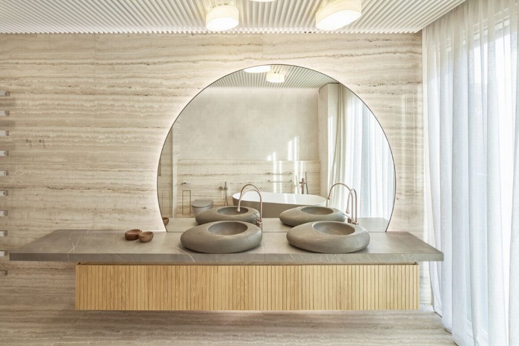 Časť kúpeľne s dvoma dizajnovými umývadlami a zrkadlom.