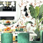 Interiér so stolom, stoličkami, vzorovanou tapetou a rastlinou v kúte.
