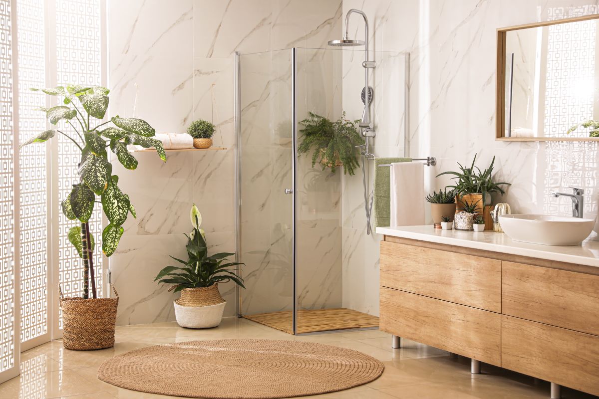 Časť bielo-drevenej kúpeľne so zelenými rastlinami.