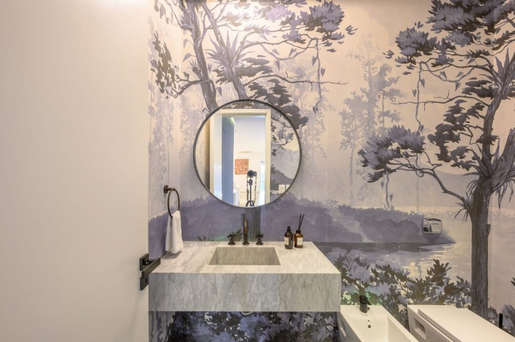 Toaleta s tapetou s krajinným vzorom.