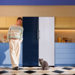 Samsung Muž pri modro-bielej dvojdverovej chladničke v kuchyni.