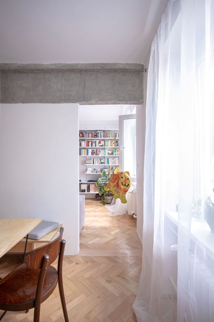 Časť interiéru so stoličkou a knižnicou v byte v Bratislave.