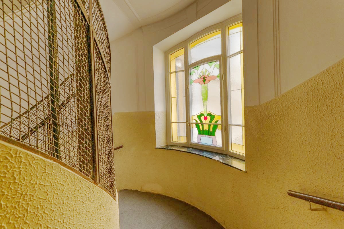 Schodisko v historickej budove zdobí vitrážové okno.