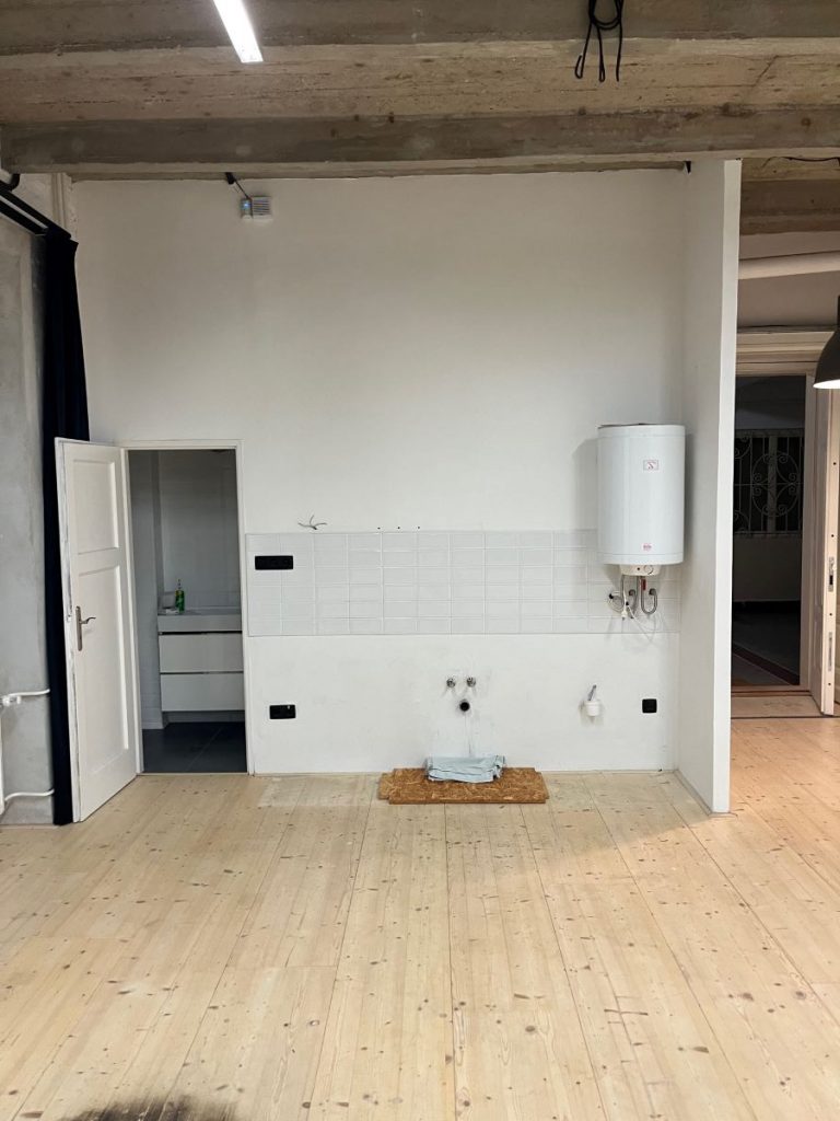 Zvyšok pôvodnej bielej kúpeľne bez stien v byte pred rekonštrukciou.