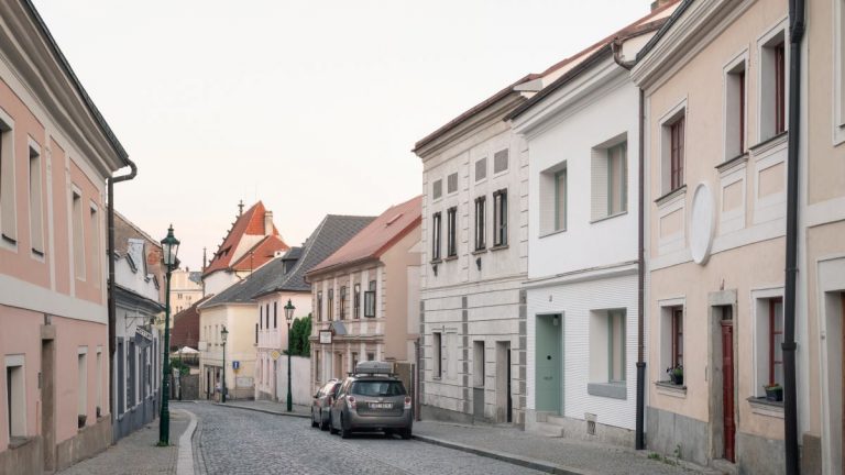 Medzi zdobenými fasádami pôsobí tento radový dom trocha jednoducho. Vo vnútri však obyčajný interiér rozhodne nečakajte