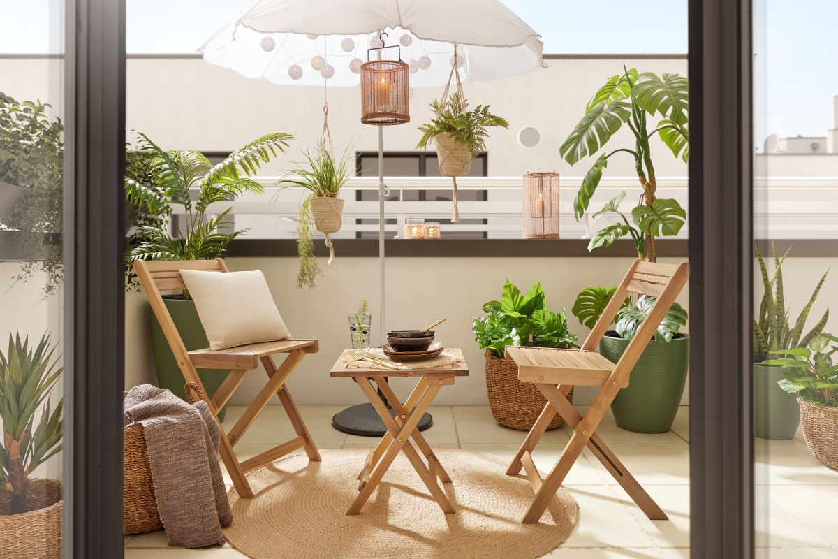 Pohľad na skladací drevený nábytok a zeleň na balkóne.