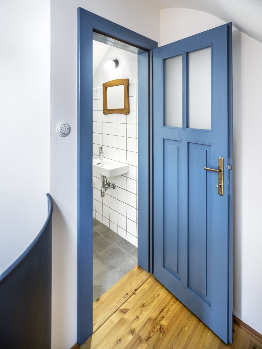 Otvorené modré dvere do kúpeľne.