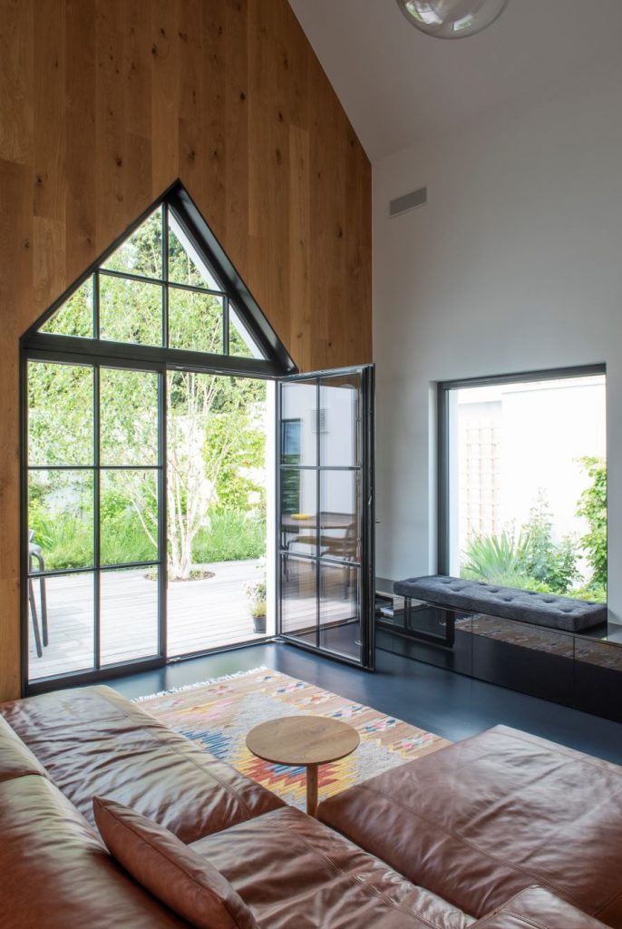 Otvorené presklené dvere na terasu z modernej obývačky.