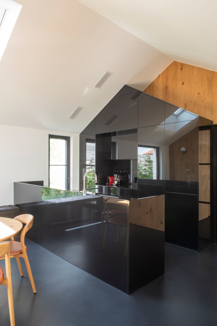 Moderná čierna kuchynská linka v minimalistickom prevedení v stave domčeka.