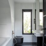 Čierno-biela moderná kúpeľňa s umývadlom, toaletou a vaňou.