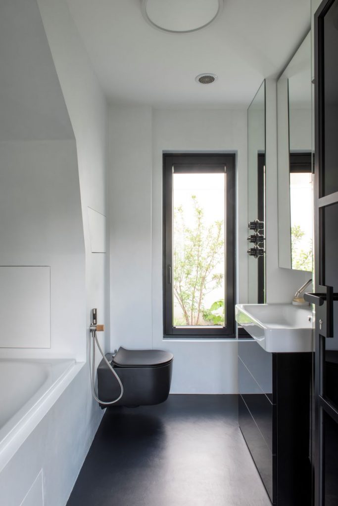 Čierno-biela moderná kúpeľňa s umývadlom, toaletou a vaňou.