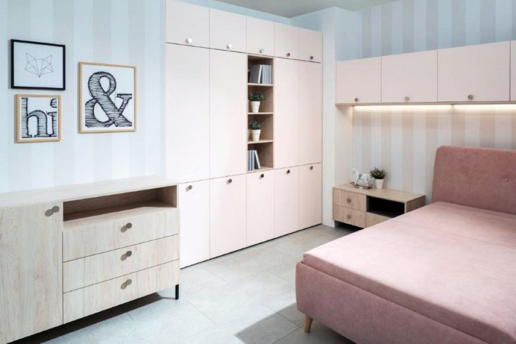 Nadčasová dievčenská izba v tlmenej ružovej farbe s množstvom úložných priestorov.