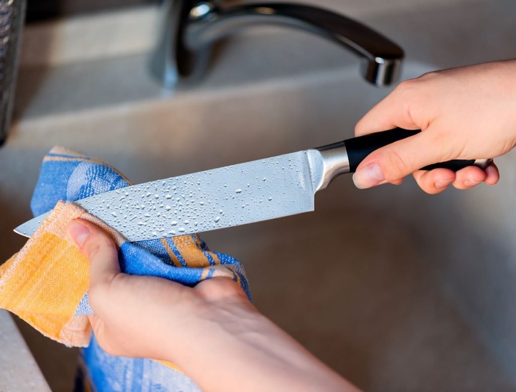 Utieranie umytého noža do utierky.