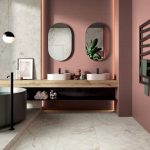 Štýlová kúpeľňa s drevenou doskou s dvoma umývadlami, vaňou a ružovými stenami.