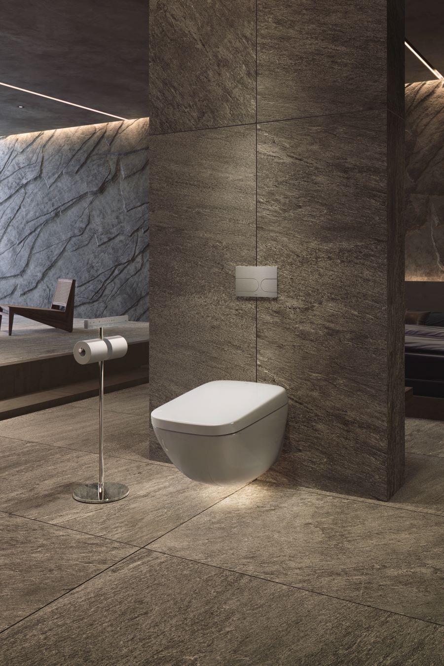 Časť modernej kúpeľne s kamenným obkladom, podsvietenou toaletou a LED pásikmi v strope.