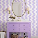 Interiér s orgovánovou komodou a umývadlom v retro štýle, zrkadlom a fialovo-bielymi vlnkoami na stene.