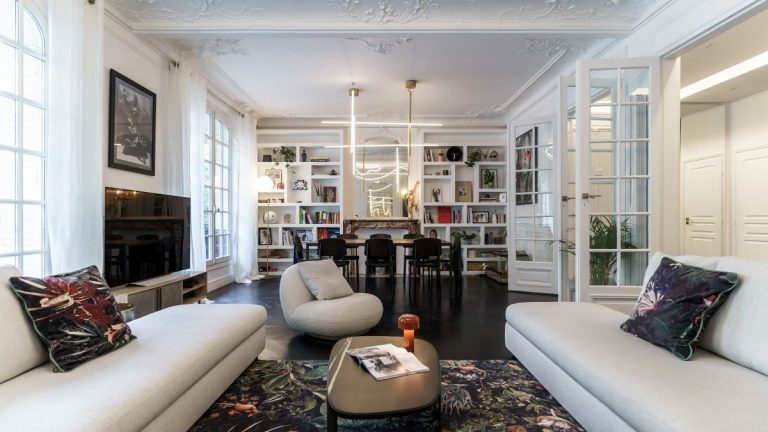 Elegantný obývací priestor s moderným nábytkom a dekoráciami v svetlých farbách.